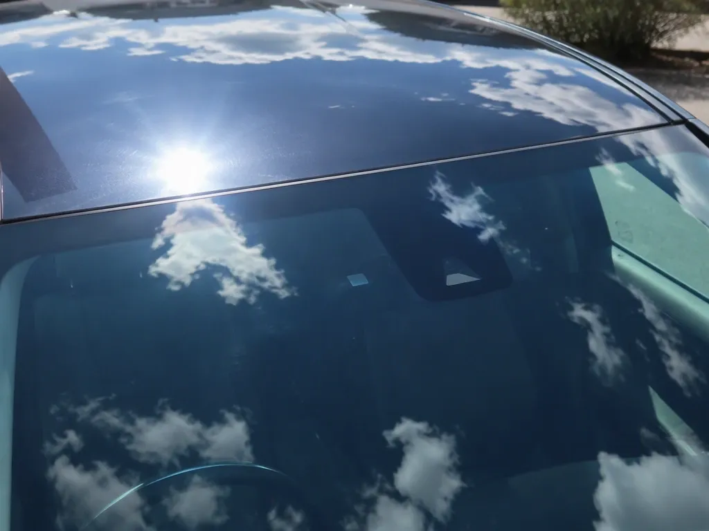 青空駐車中の車のルーフに照りつける強い日差し